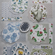 Assorted reversible scalloped placemats in botanical prints, flat lay.