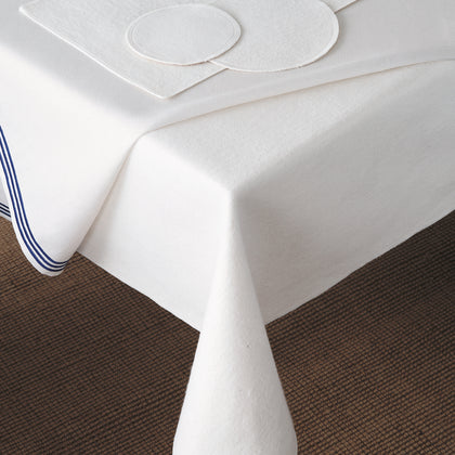 Felt table silencer pad layered under a white tablecloth with blue trim