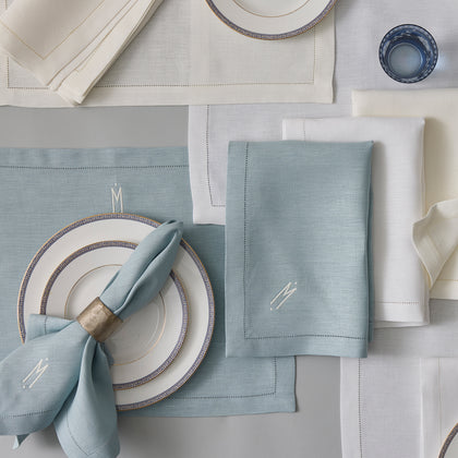 Blue and ivory Valentina Hemstitch linen napkins and placemats, set with greek-key bordered china.
