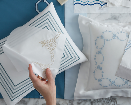 Hand selecting embroidered linen swatches at the House of Matouk boutique