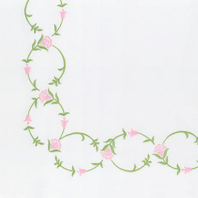 A close-up of a white fabric or paper surface with a decorative corner design featuring pink flowers and green vines.