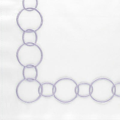 Close up of a napkin decorated with a lavender embroidered border of interlocking oval links.