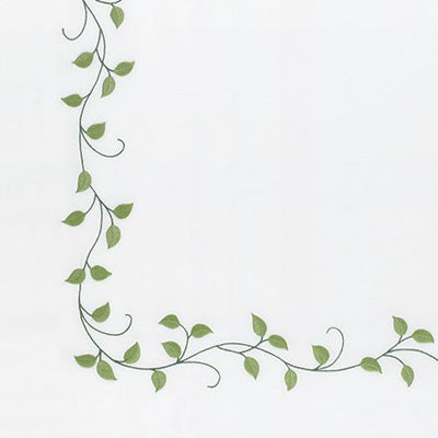 Close up of a napkin with ag reen vine and leaf corner border design