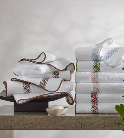 White Astor Braid towels with an embroidered trim, in assorted colors.