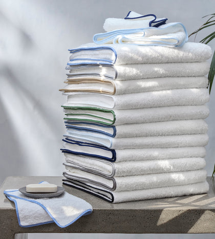 White Cairo towels with assorted colored trim, stacked.