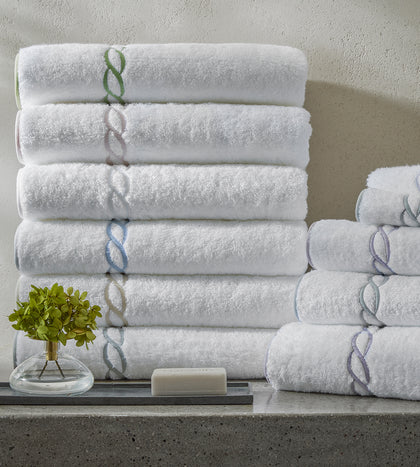 White Classic Chain towels with an embroidered trim, stacked.