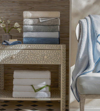 Enzo towels with linen piping in an ombre stack.