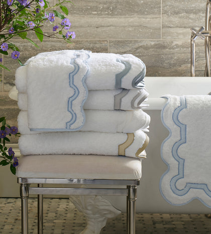 White Mirasol towels with an arch-trim border, stacked.