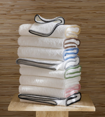 White Whipstitch towels with a contrast edge, stacked.