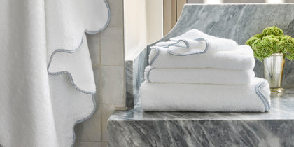 White Jasper bath mat with a scalloped blue border.