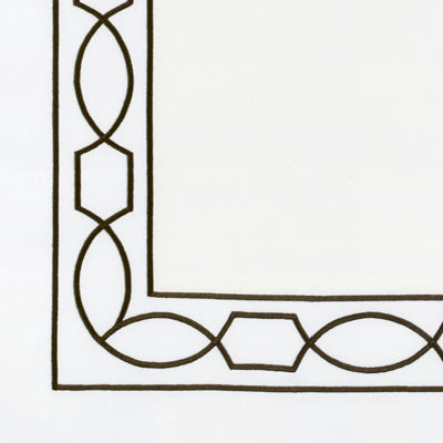 Close up of a napkin featuring a black geometric border design in the bottom-left and top-left corners.