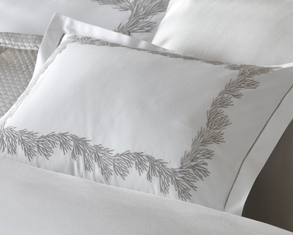 An embroidered white pillow sham.
