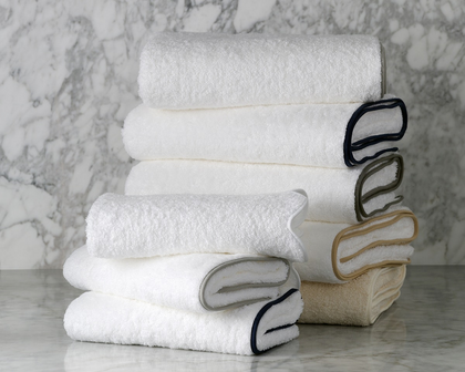 A stack of white towels on a marble counter. 