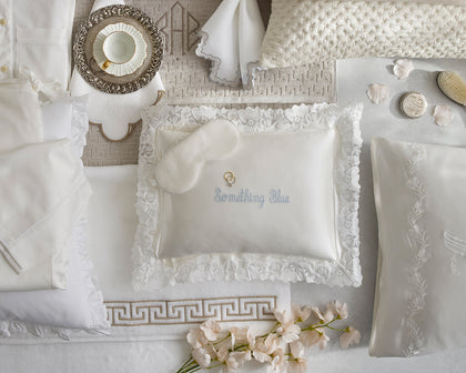 Wedding-themed flat lay with a personalized lace pillow and sleep mask.