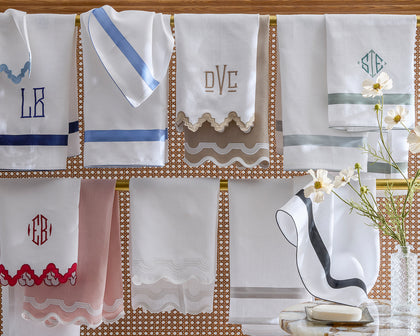 Assorted monogrammed guest towels, hanging.