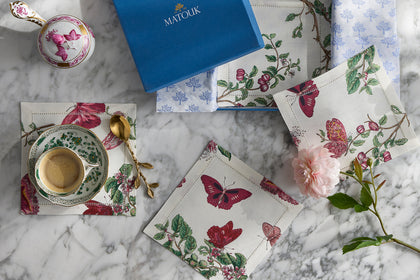 Butterfly-print cocktail napkins with a table setting and gift box.
