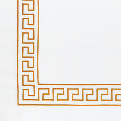 Close up of a napkin featuring a gold Greek key border pattern along the left and bottom edges.