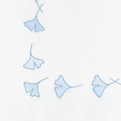 Close up of a napkin with light blue line-art illustrations of ginkgo leaves