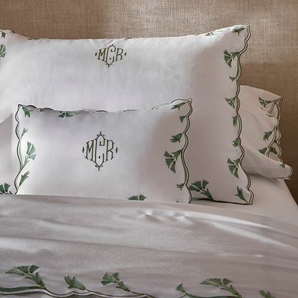 Embroidered vine-pattern bedding with a diamond-frame monogram on shams