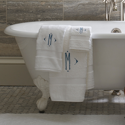 Towels on a clawfoot tub with a diamond-frame monogram