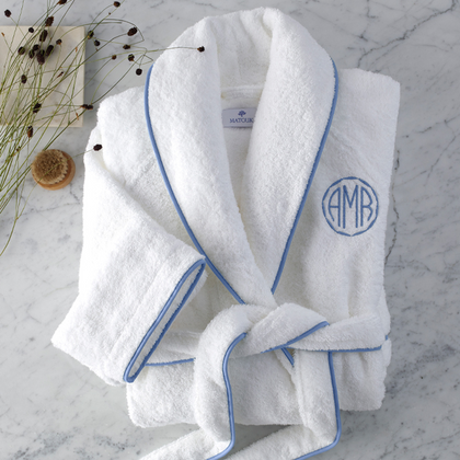 Folded robe with piped trim and a circular monogram