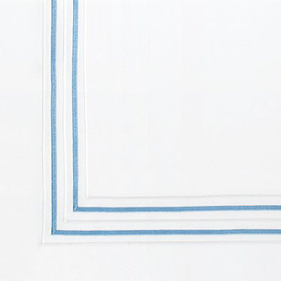 Close up of a napkin featuring a delicate double border design in light blue.