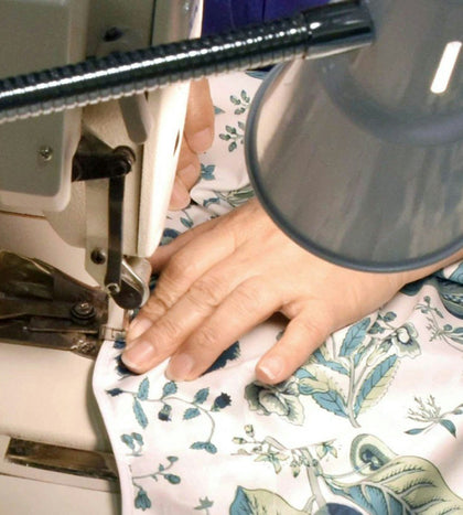 Close-up of a seamstress sewing Schumacher floral fabric.