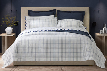 White August Plaid bedding with navy accents, styled on a bed.