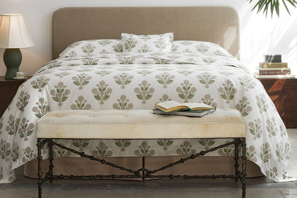 Dalila pebble floral duvet cover styled on a bed with a bench
