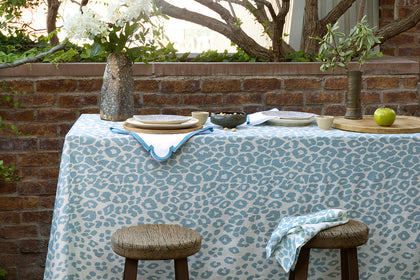 Pale blue Iconic Leopard tablecloth set outdoors.