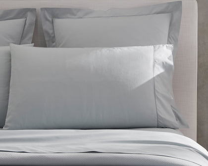 Gray Milano sheeting styled on a bed, close-up.