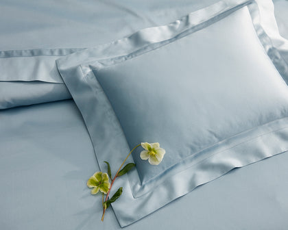 Pale blue Nocturne sheeting with a flower accent, close-up.
