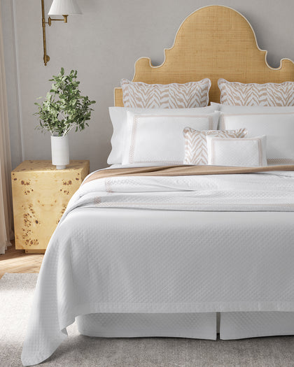White Astor Braid Matelasse quilted bedding with tan loop-embroidered trim and zebra-print accent pillows.