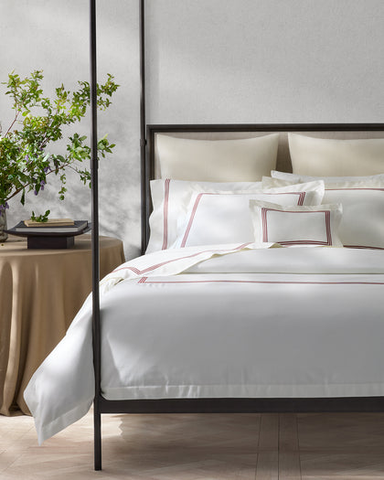 White Bel Tempo Nocturne sheets with burgundy triple-stripe trim, styled on a bed.