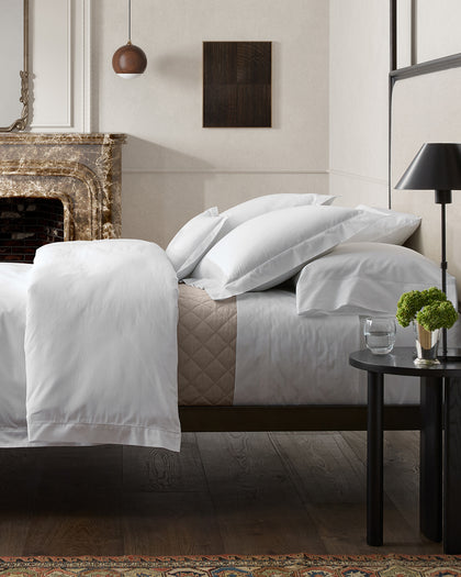 White Bergamo Hemstitch sheets styled in a bedroom.