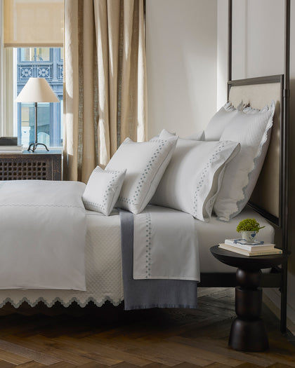 White Casablanca sheets with a diamond cross-stitch trim.
