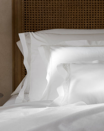 White Cecily pillows with lattice lace trim, styled against a headboard.