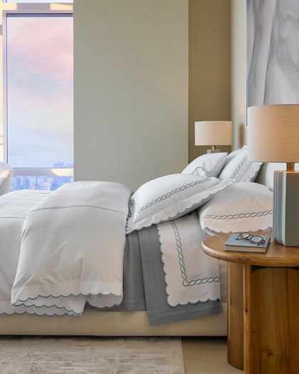 White Classic Chain Scallop bedding with gray scalloped chain-embroidered trim, styled in a bedroom.