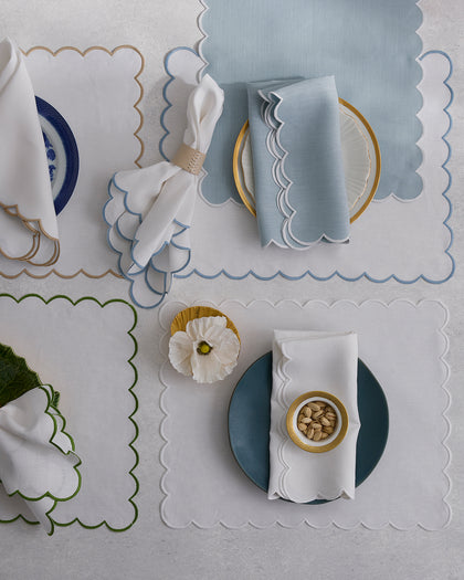 Dakota scalloped placemats in gold, blue, and green trim, set with plates and napkins from above.