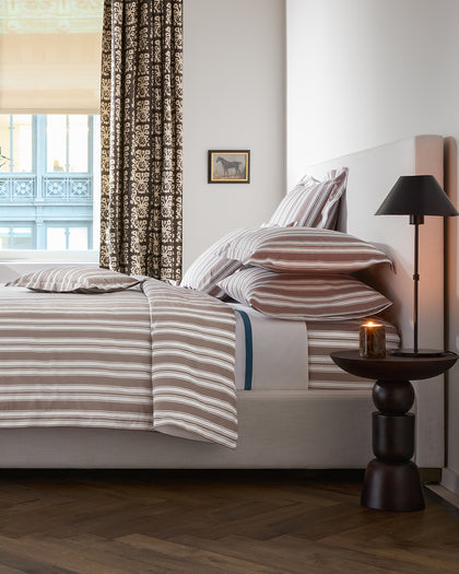Striped Elio bedding in tan and white.