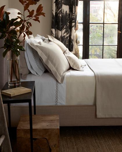 White Elliot textured pique bedding with a tan chain-link trim.