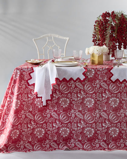 Red and white Granada floral print scalloped tablecloth, set with red berries.
