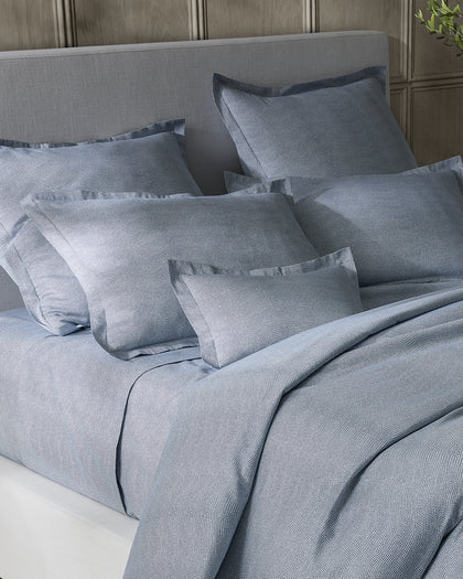 Blue-gray Jasper pebbled print bedding styled against a headboard.