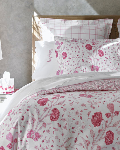 Pink Khilana floral print bedding styled against a headboard.