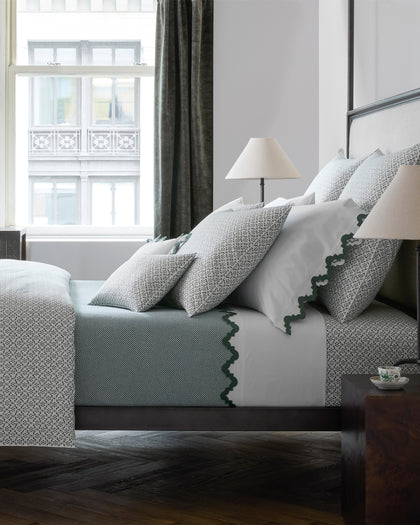 Laksha medallion print bedding in green and gray with scalloped trim sheets.