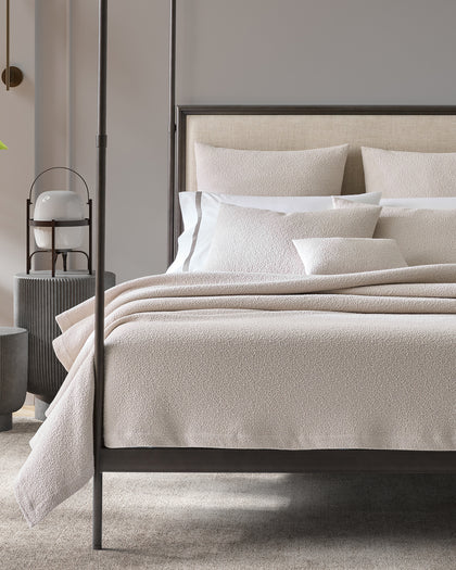 Ivory Malibu textured bouclé bedding styled on a bed.