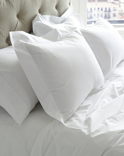 White Sierra Hemstitch sheets styled against a headboard.