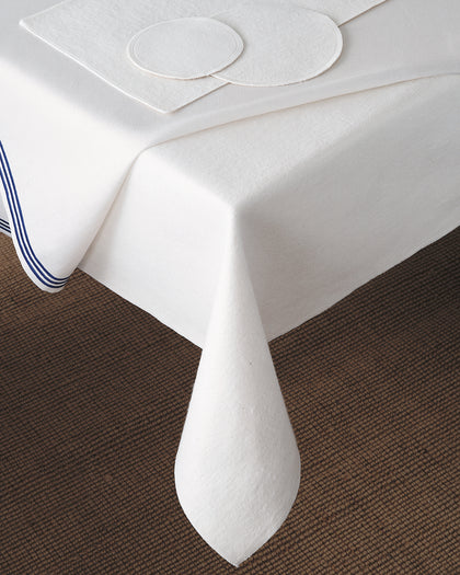 White Silencer tablecloth with a blue striped border draped over a table.