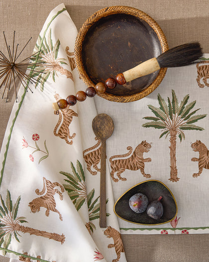 Tiger Palm print napkin and placemat with tigers and palm trees, styled with figs and a bowl.