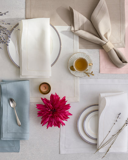 Valentina Hemstitch placemats and napkins in white, blue, pink, and tan, set with Greek key china from above.